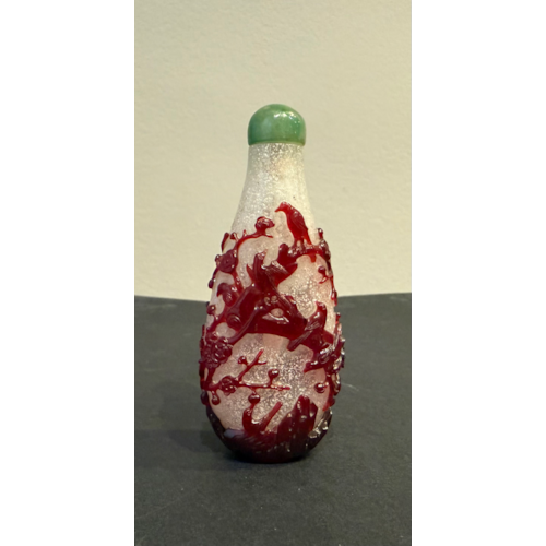 Glass snuff bottle "red overlay" ruby finely carved on a translucent bubbled background with decor of twelve pies in flight and perched on a trunk of prunus in bloom and rock China 1750/80
